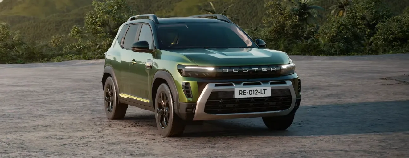 A green Renault Duster parked on a dusty trail with mountains in the background